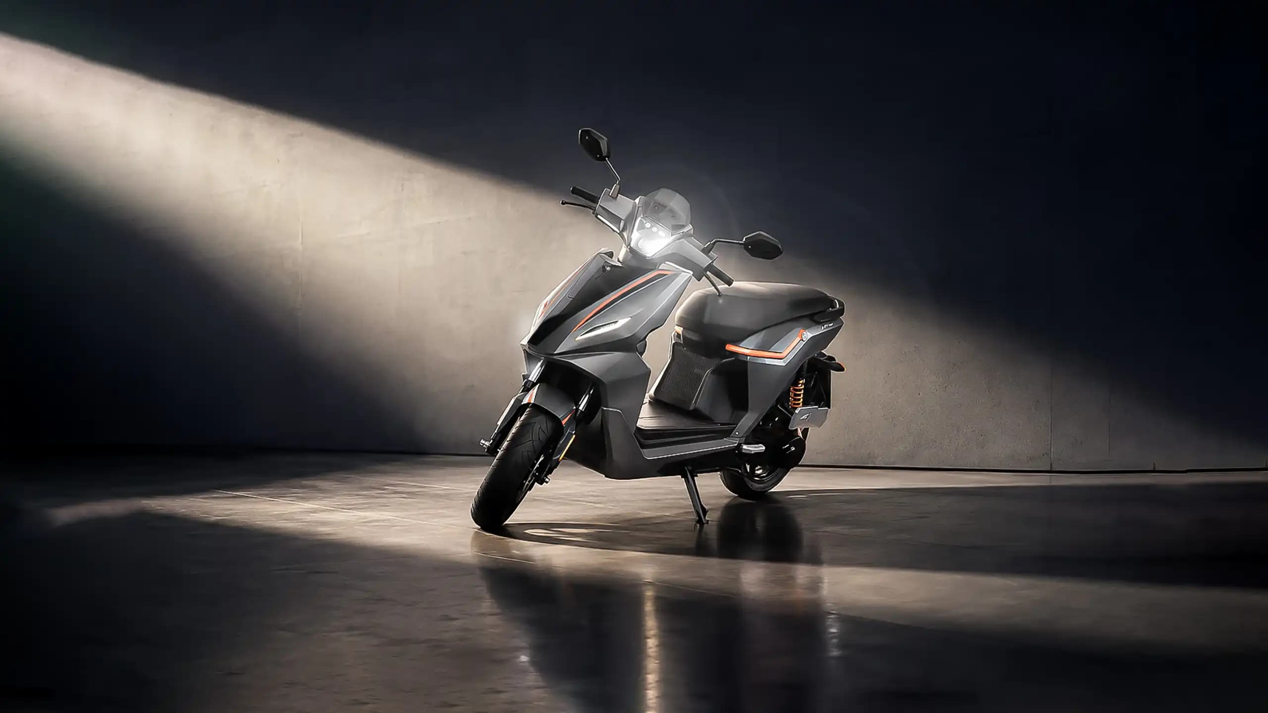 RIVOT NX100 scooter under a dramatic spotlight