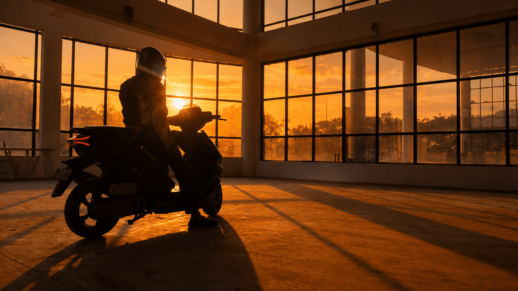 Rider with a RIVOT electric scooter at sunset